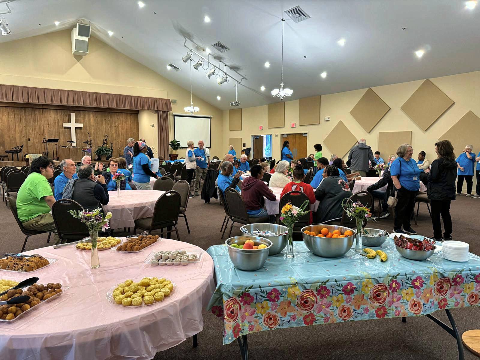 A full fellowship hall set with tables of food