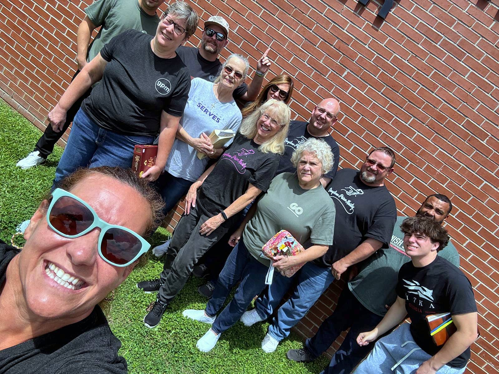 A joyful group selfie on the lawn outside the jail