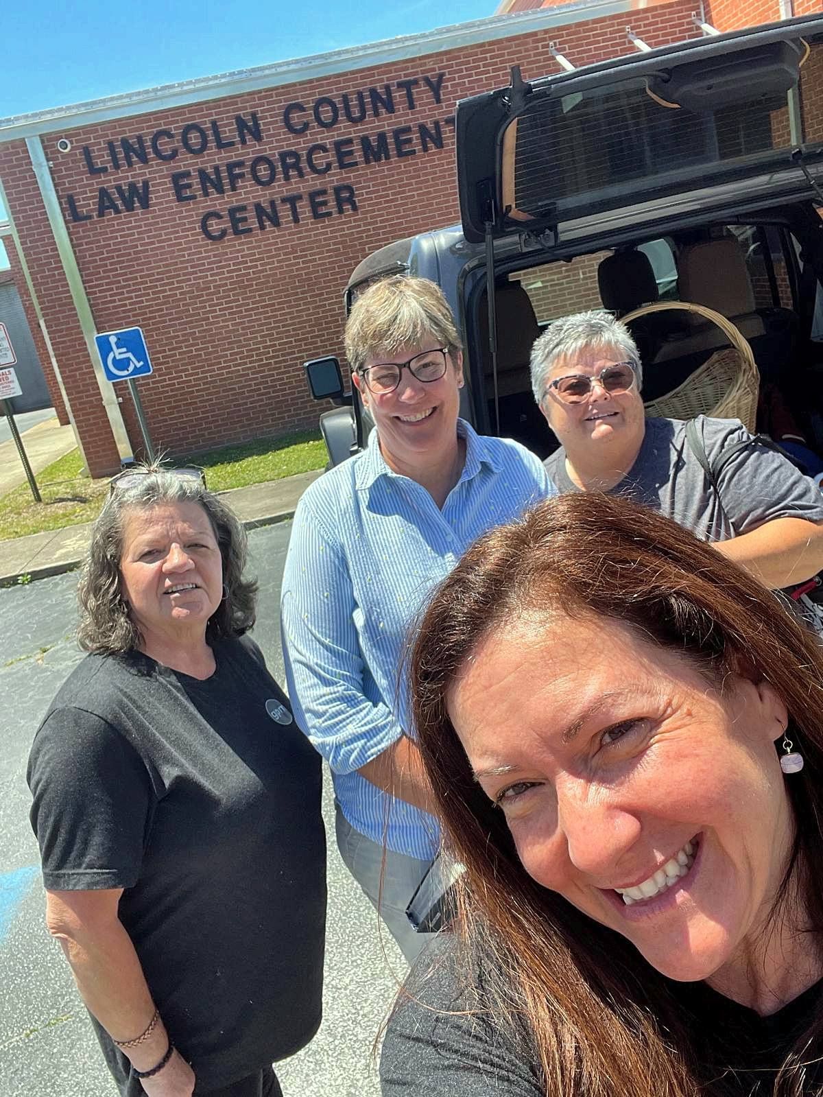 Four volunteers taking a selfie outside the jail