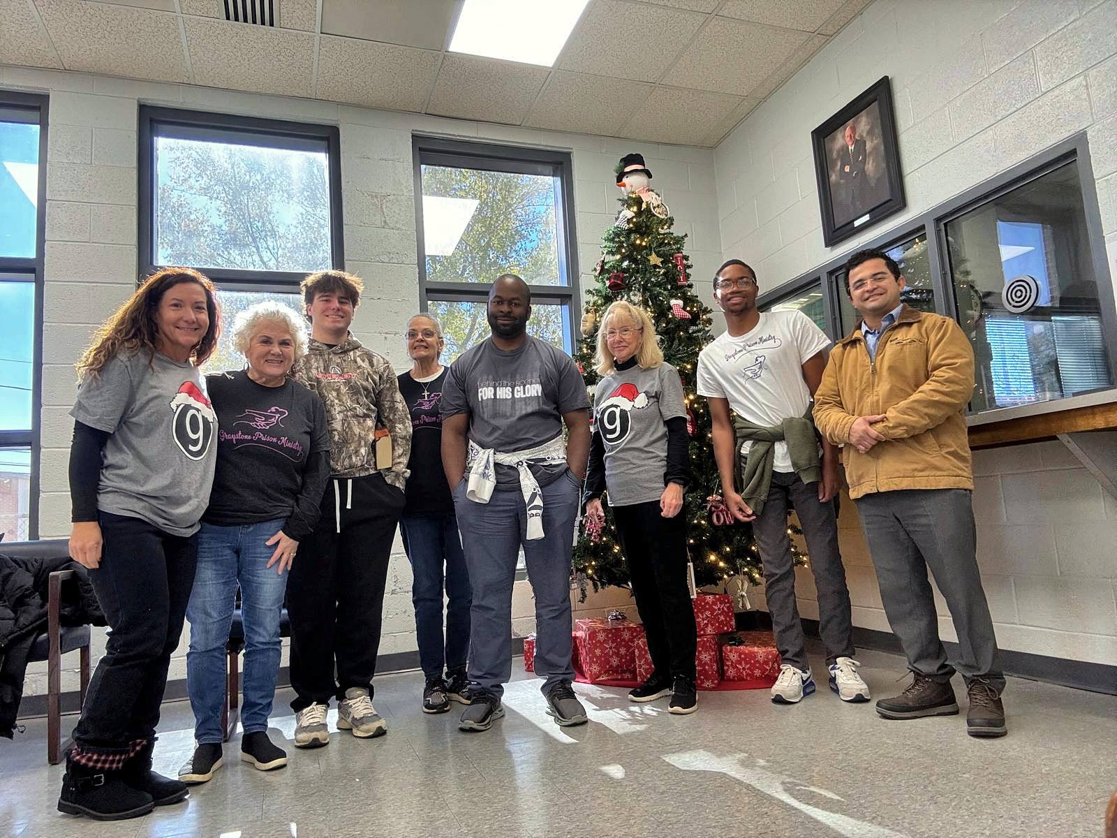 A group of volunteers beside the Christmas tree in the jail lobby