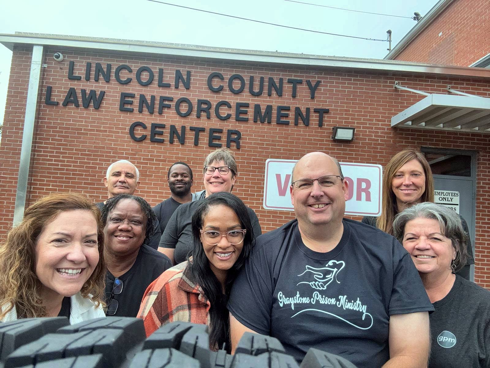 A smiling selfie of the team at the visitor sign