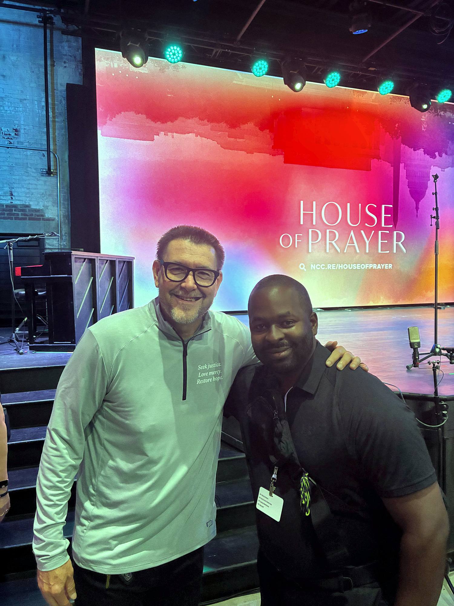 Jamil with Pastor Mark Batterson in front of a House of Prayer stage