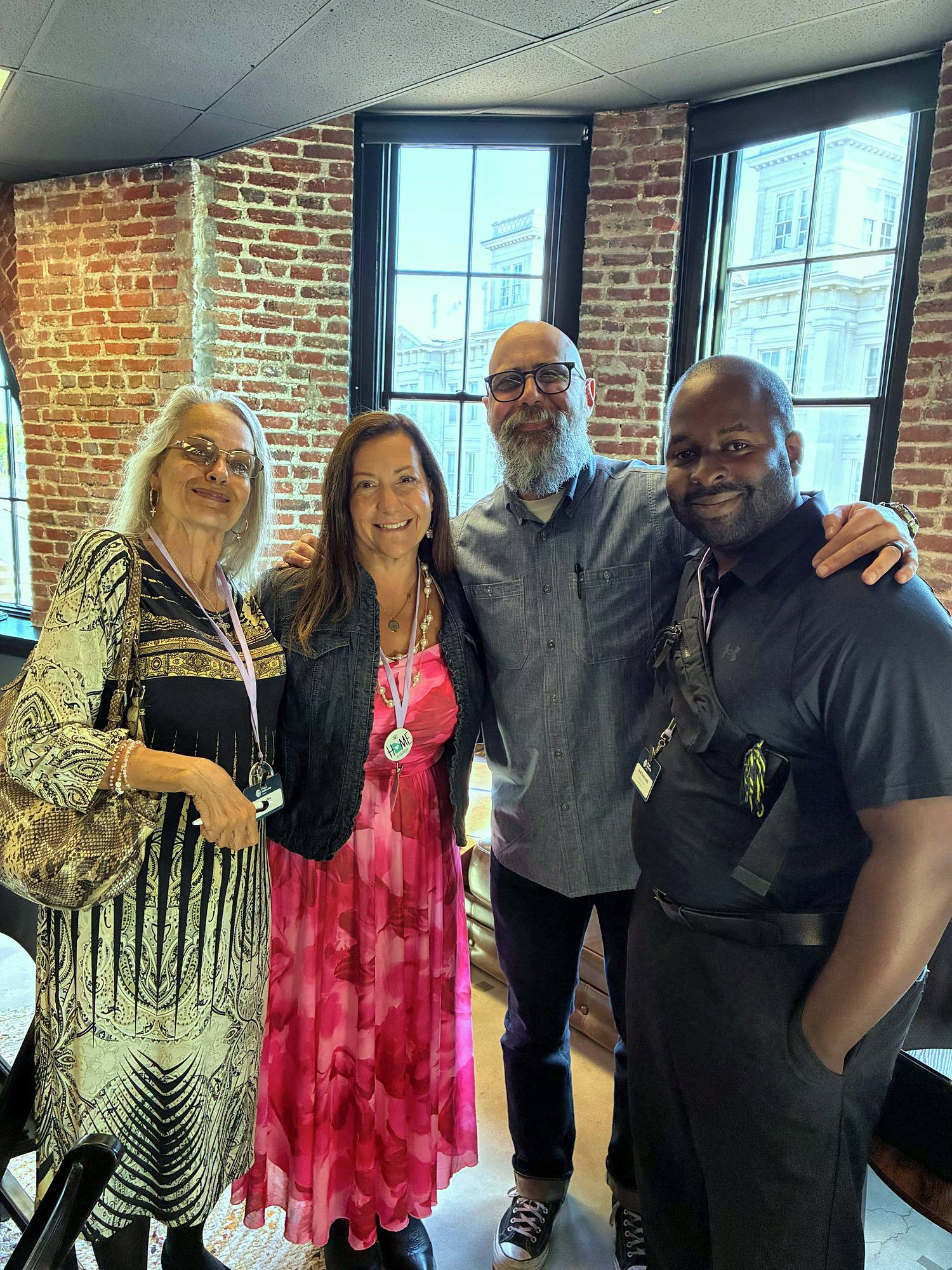 Four people smiling together at Restore 2026, including Johnny Baker of Celebrate Recovery