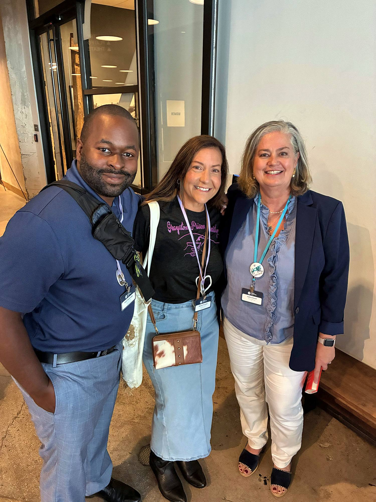 Three friends smiling together at Restore 2026
