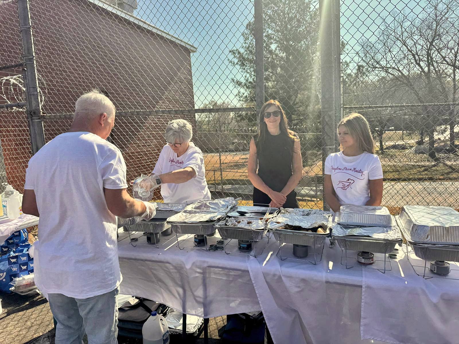 Volunteers serving food from chafing dishes