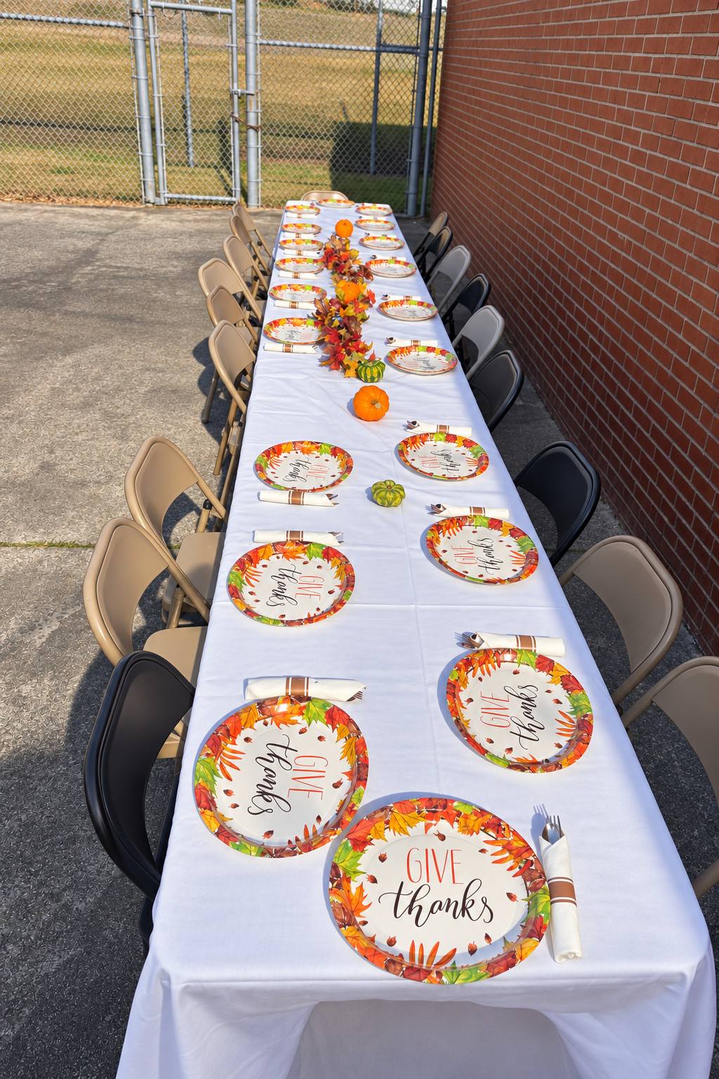 A long table set with “Give Thanks” plates in the jail yard