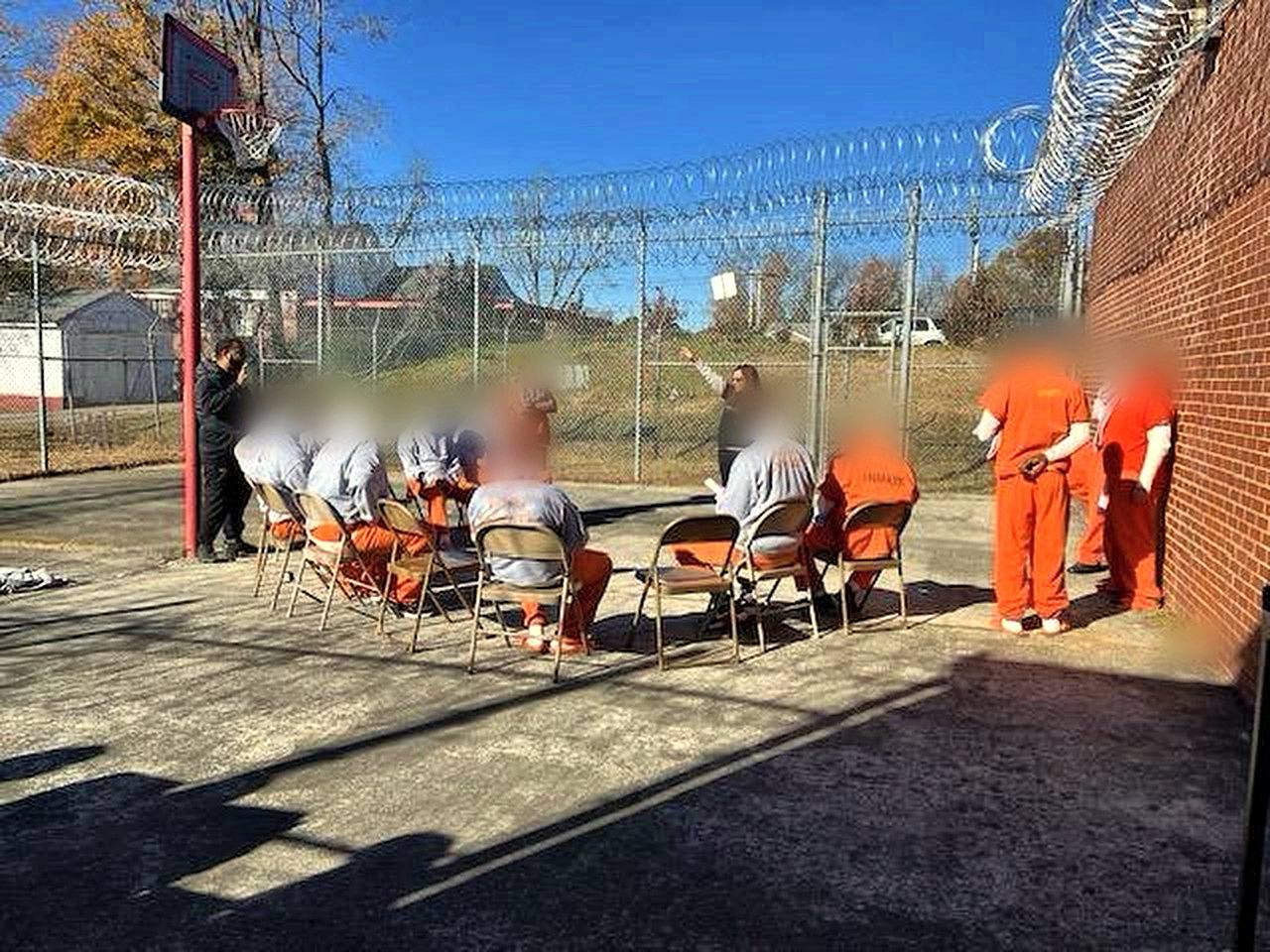 Another view of inmates gathered in the yard for worship; faces are blurred for privacy